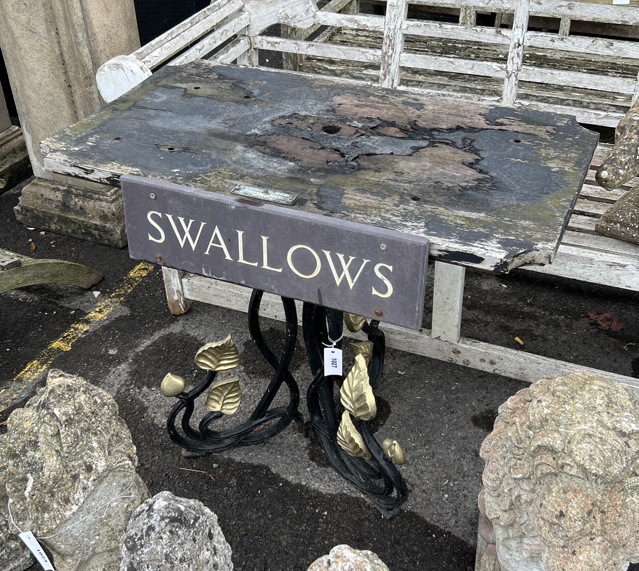 A rectangular cast iron and weathered teak garden table with a sign reading 'Swallows', width 91cm, depth 53cm, height 71cm
